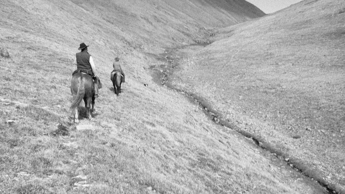 Two horse riders in mountains