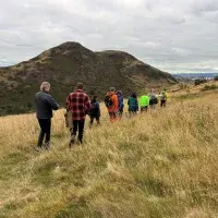 group of people walking over a hill